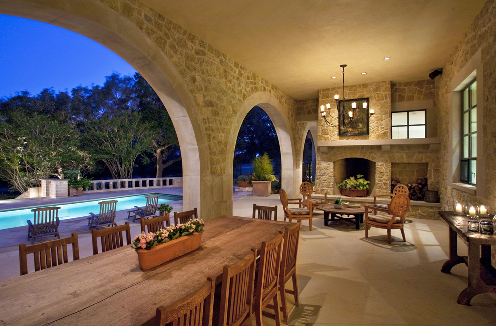 Inspiration for a large traditional back patio in Austin with a fire feature and a roof extension.