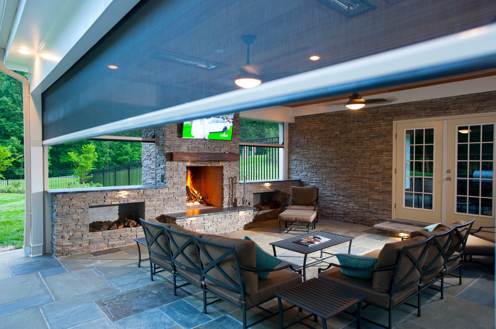 Photo of a large classic back patio in DC Metro with an outdoor kitchen, stamped concrete and a pergola.