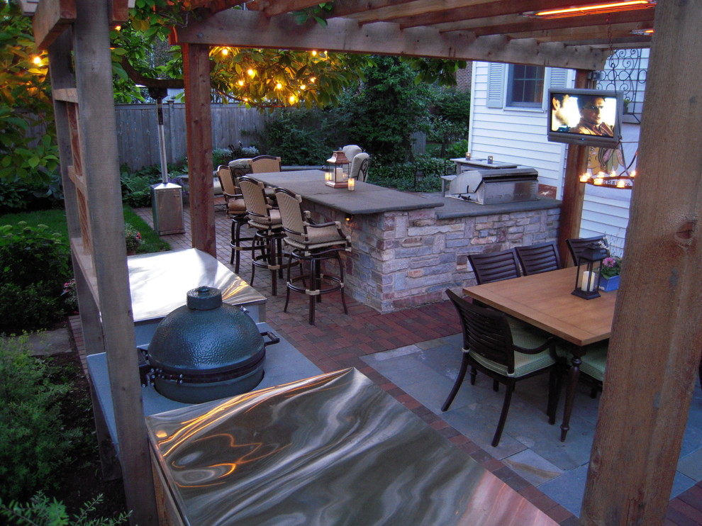 Foto di un patio o portico tradizionale di medie dimensioni e dietro casa con un focolare, pavimentazioni in mattoni e una pergola