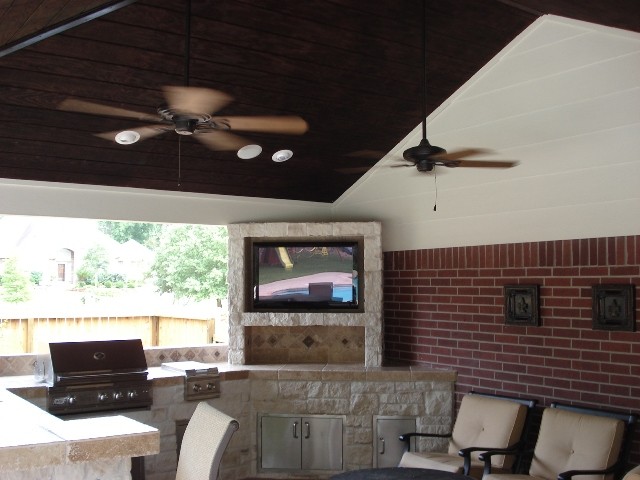 This is an example of a contemporary back patio in Houston with a roof extension.