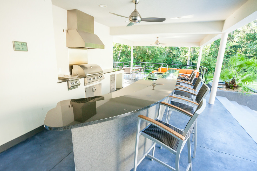 Mittelgroßer, Überdachter Moderner Patio hinter dem Haus mit Outdoor-Küche und Betonplatten in Orlando