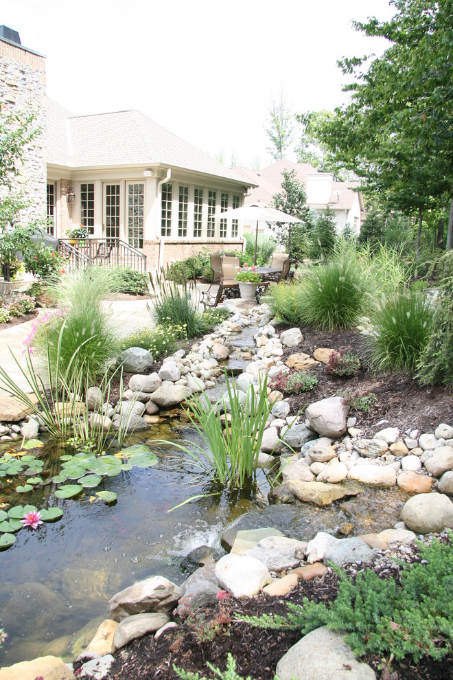 Design ideas for a large traditional back garden in Cincinnati with a water feature and natural stone paving.
