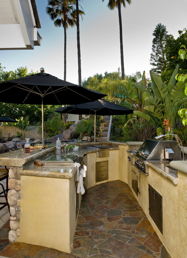 This is an example of a world-inspired patio in Orange County with a bar area.