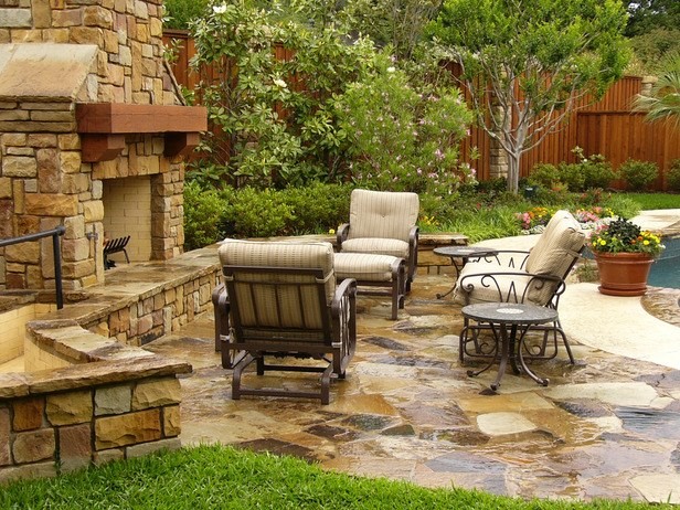 This is an example of a medium sized classic back patio in Dallas with no cover, a fire feature and natural stone paving.