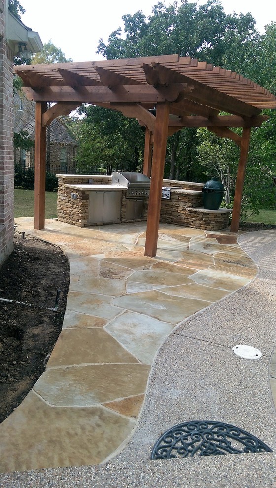 Design ideas for a large traditional back patio in Dallas with an outdoor kitchen, natural stone paving and a pergola.