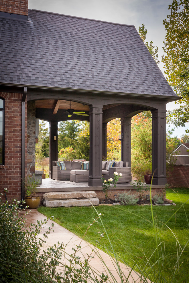 Ispirazione per un patio o portico classico di medie dimensioni e dietro casa con un giardino in vaso, pavimentazioni in pietra naturale e un tetto a sbalzo