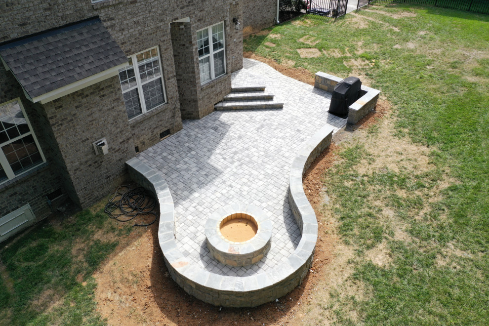 Esempio di un grande patio o portico design dietro casa con un focolare, pavimentazioni in cemento e nessuna copertura