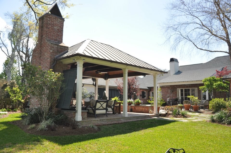 Foto di un grande patio o portico tradizionale dietro casa con pavimentazioni in mattoni, un gazebo o capanno e un focolare
