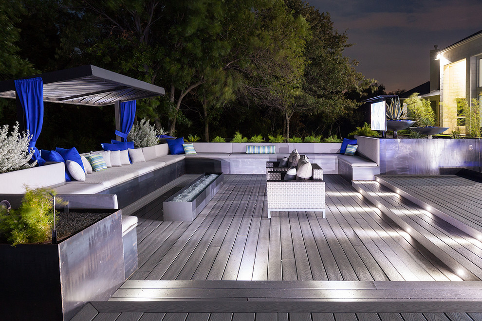 This is an example of a large contemporary back patio in Dallas with an outdoor kitchen, concrete paving and a roof extension.