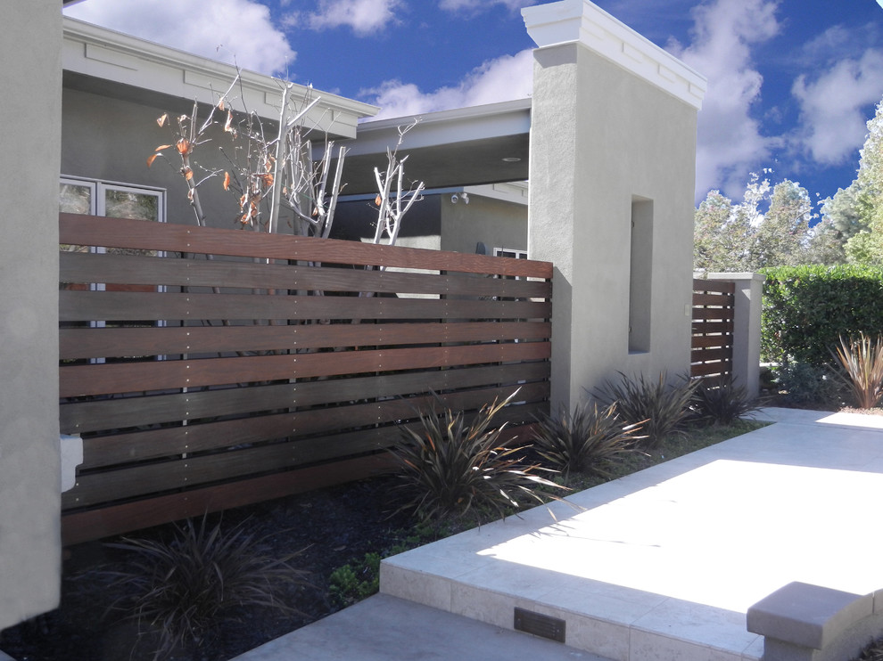 Idee per un patio o portico minimal di medie dimensioni e davanti casa con piastrelle e un tetto a sbalzo
