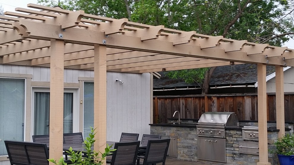 Immagine di un patio o portico chic di medie dimensioni e dietro casa con lastre di cemento e una pergola