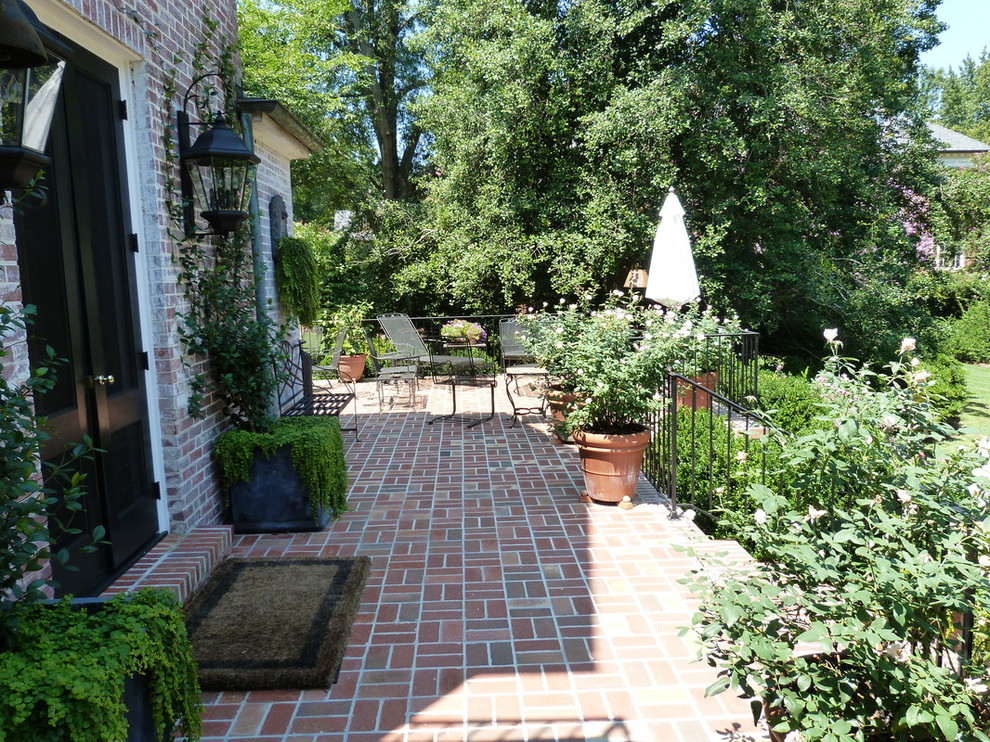 Foto de patio clásico renovado de tamaño medio sin cubierta en patio delantero con jardín de macetas y adoquines de ladrillo