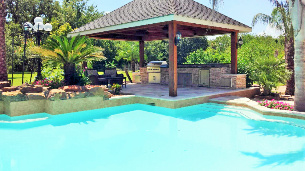 Photo of a world-inspired patio in Houston with an outdoor kitchen, natural stone paving and a gazebo.