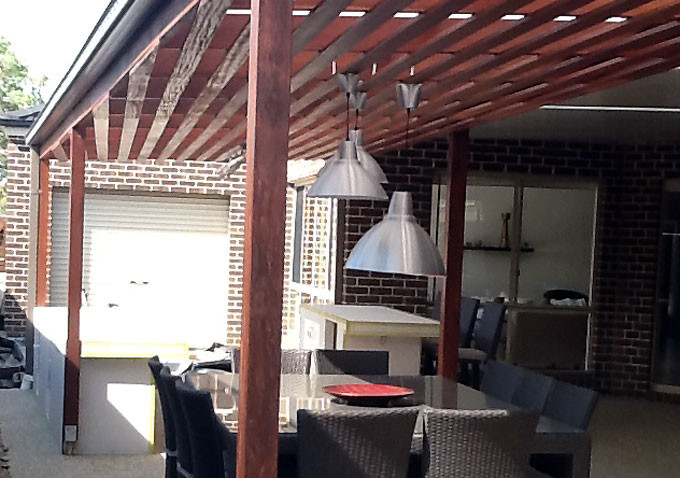Exemple d'une grande terrasse latérale moderne avec une cuisine d'été, une dalle de béton et une extension de toiture.