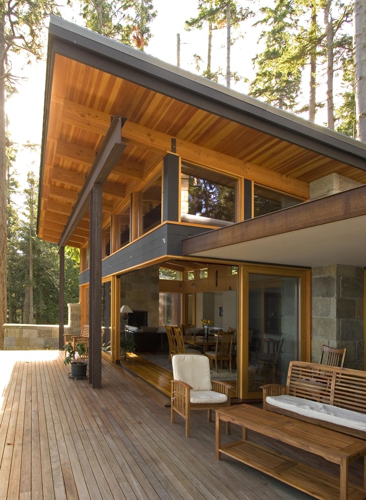 Immagine di un grande patio o portico minimal dietro casa con pedane e un tetto a sbalzo