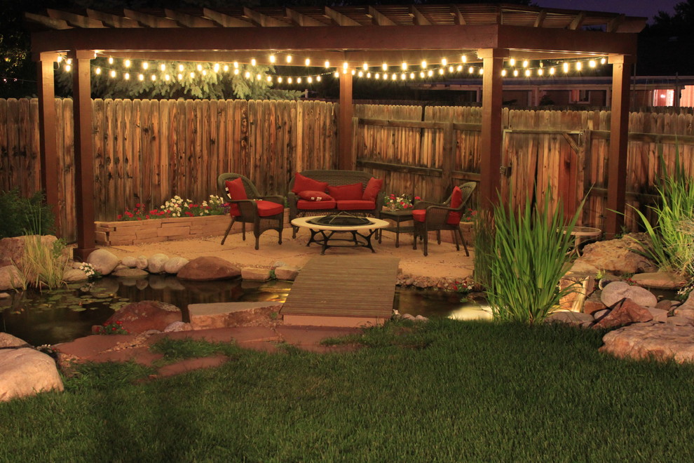 Large traditional back patio in Denver with a fire feature, natural stone paving and a pergola.
