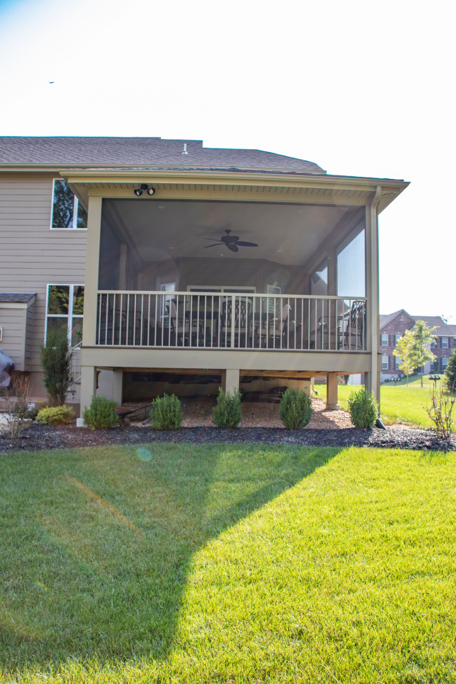 Foto di un patio o portico di medie dimensioni e dietro casa con un focolare, cemento stampato e un tetto a sbalzo