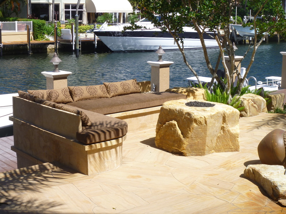Design ideas for a contemporary back patio in Miami with natural stone paving.