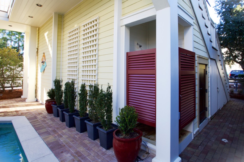 Immagine di un patio o portico stile marino di medie dimensioni con pavimentazioni in mattoni