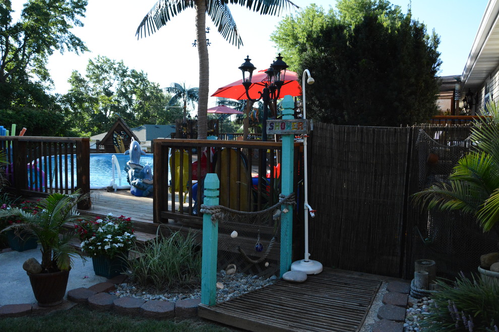 Foto på en mellanstor tropisk uteplats på baksidan av huset, med utedusch, grus och en pergola
