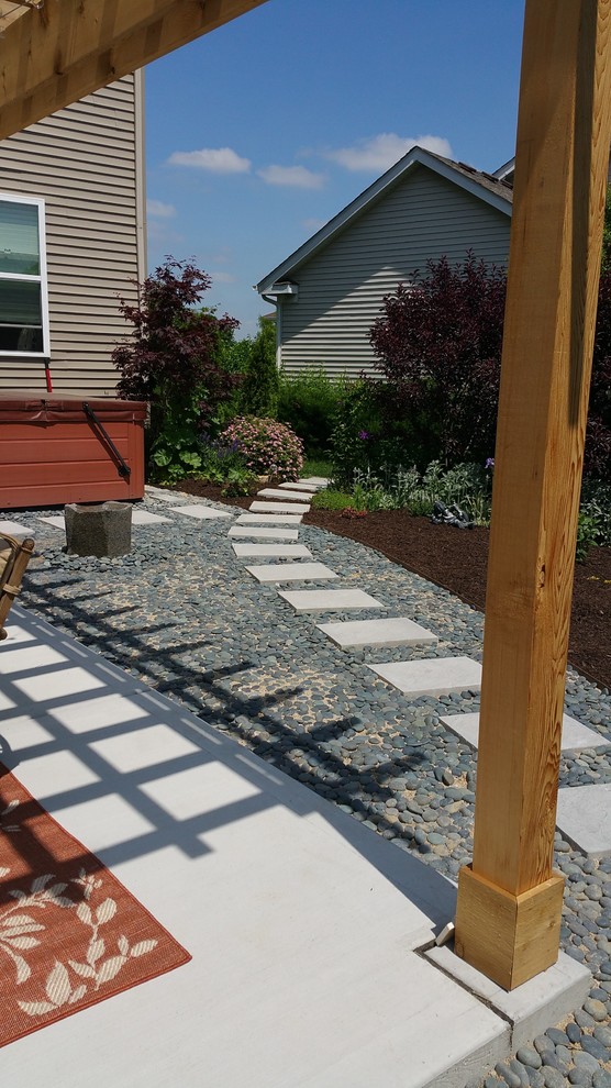 Cette photo montre une terrasse arrière tendance de taille moyenne avec un point d'eau, une dalle de béton et une pergola.