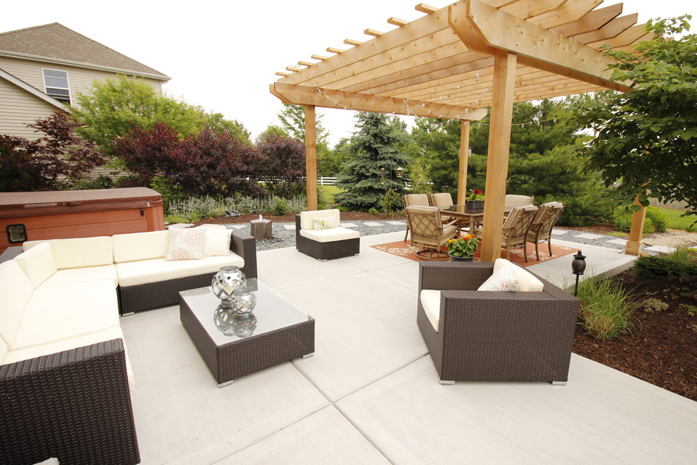 Medium sized contemporary back patio in Chicago with a water feature, concrete slabs and a pergola.