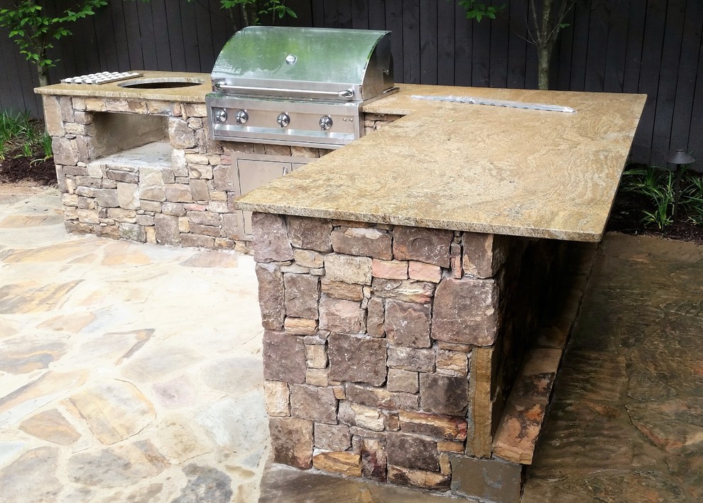 Modelo de patio tradicional pequeño en patio trasero con cocina exterior y adoquines de piedra natural