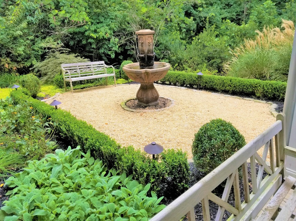 На фото: маленький садовый фонтан на внутреннем дворе в классическом стиле с покрытием из каменной брусчатки для на участке и в саду с