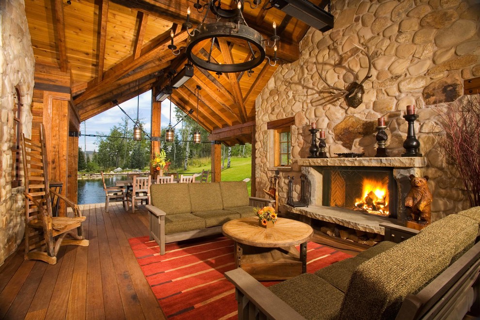 Inspiration for a rustic patio in Las Vegas with a fire feature, decking and a roof extension.