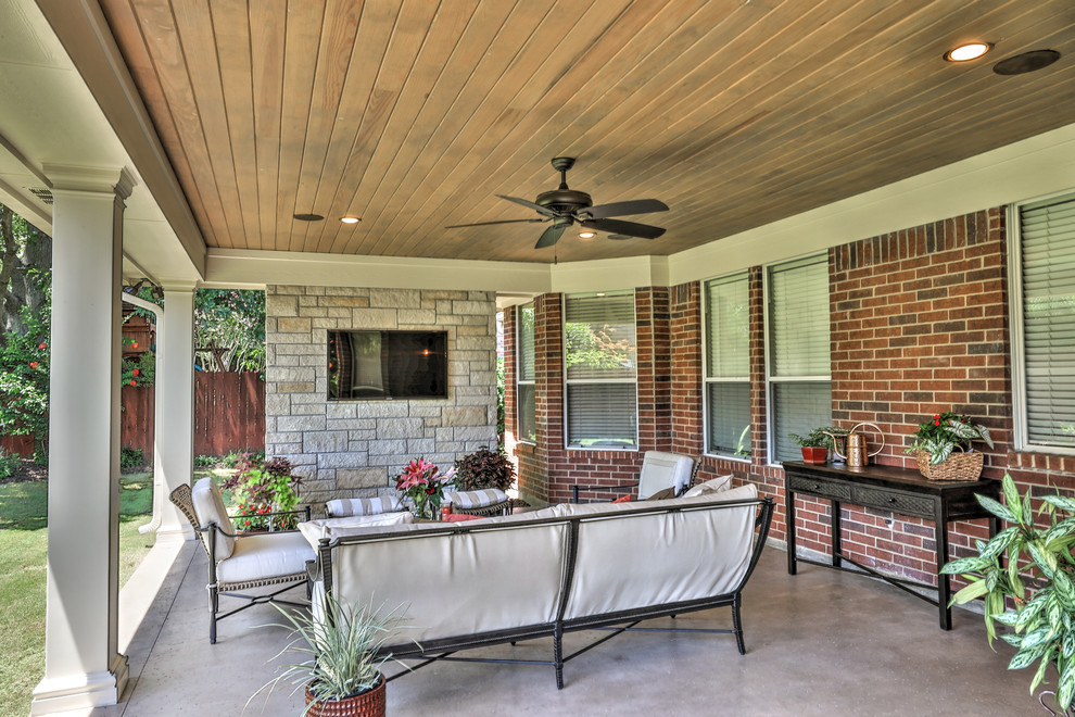 Foto di un grande patio o portico classico dietro casa con lastre di cemento e un tetto a sbalzo