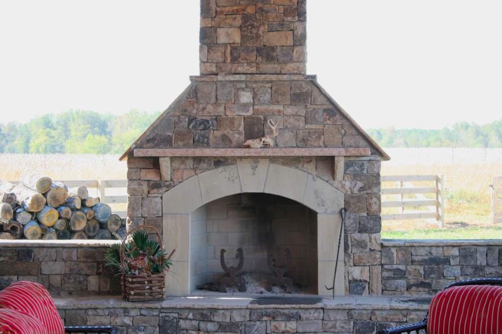 Cette image montre une terrasse arrière chalet de taille moyenne avec une cheminée, des pavés en pierre naturelle et aucune couverture.