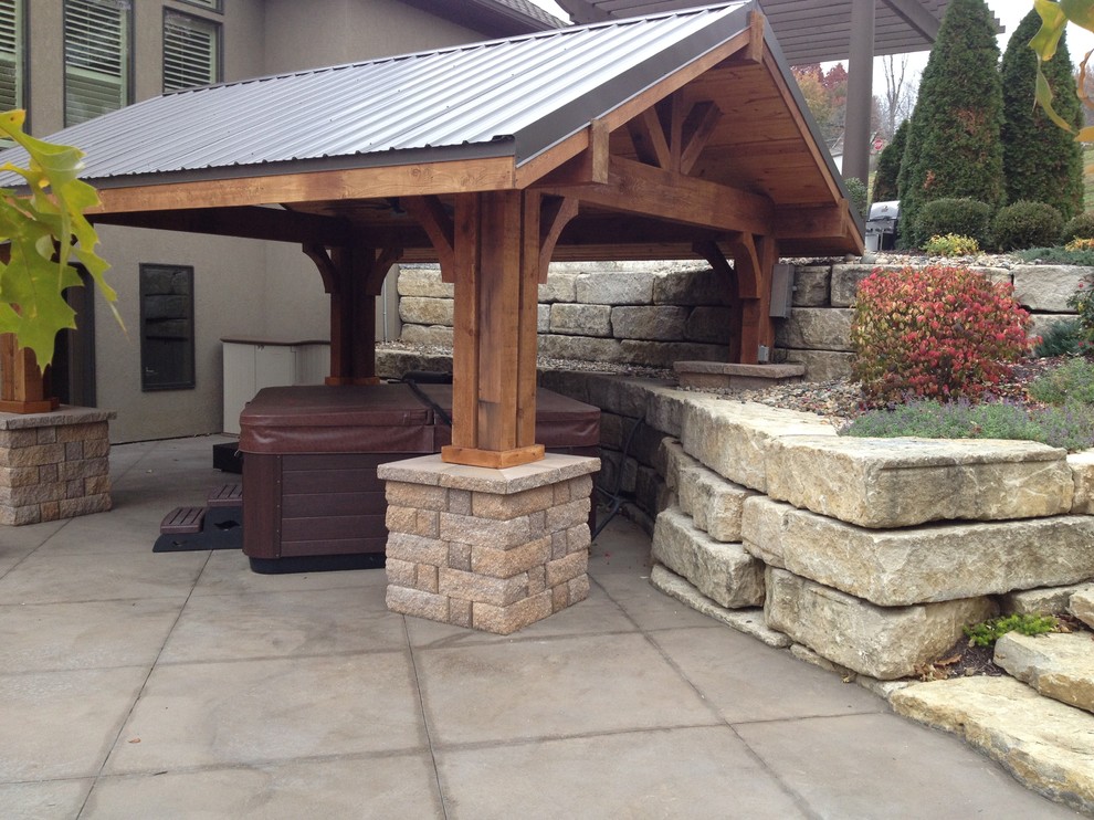Esempio di un patio o portico tradizionale con lastre di cemento e un gazebo o capanno