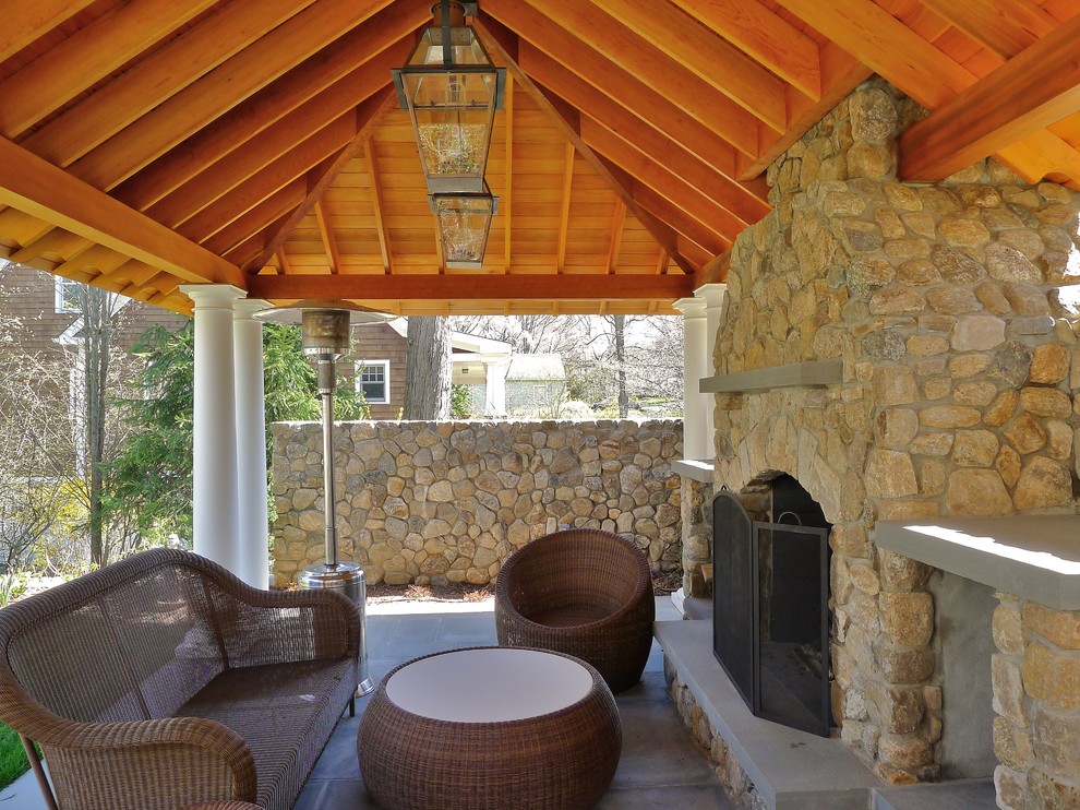 Example of a large classic backyard stone patio design in New York with a gazebo and a fire pit