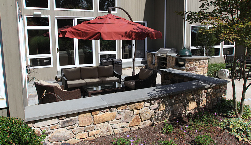 Modelo de patio de estilo americano extra grande sin cubierta en patio trasero con cocina exterior y adoquines de hormigón