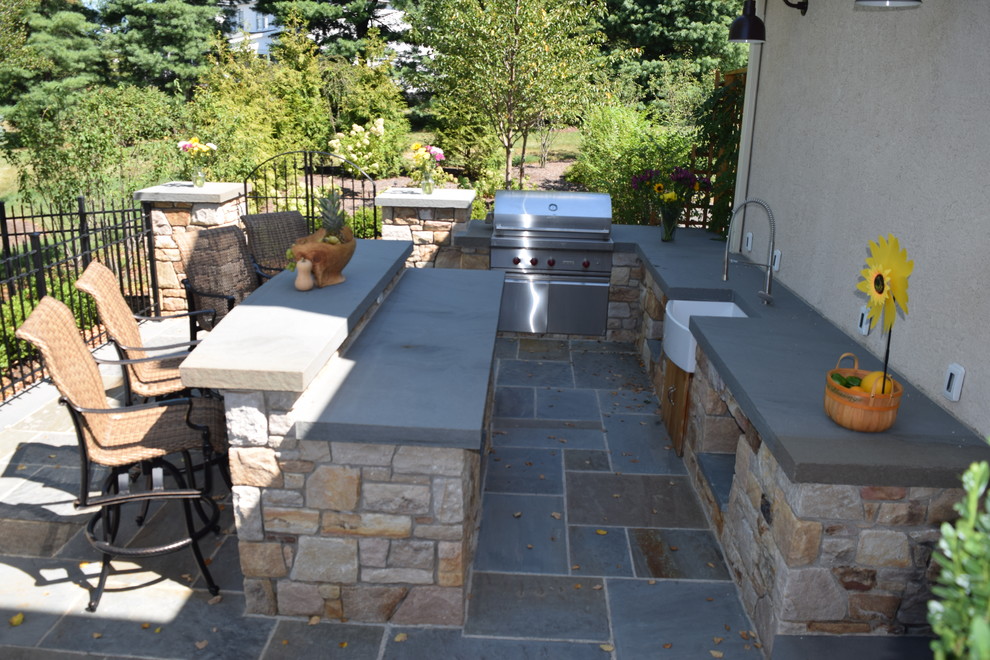 Ejemplo de patio de estilo americano de tamaño medio sin cubierta en patio trasero con cocina exterior y adoquines de hormigón