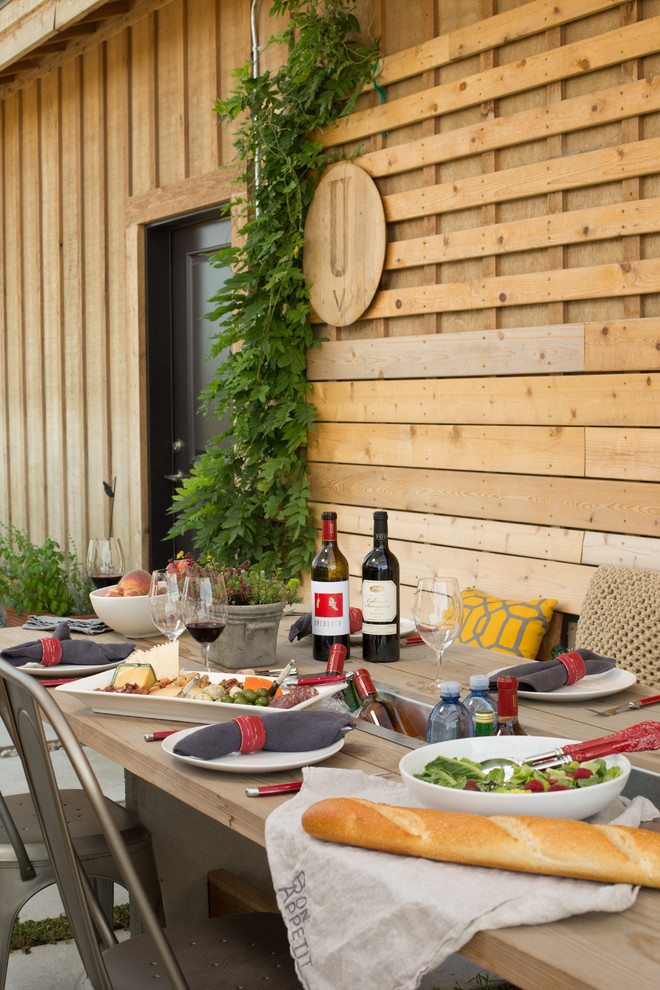 Aménagement d'une petite terrasse latérale campagne avec une cuisine d'été, des pavés en béton et une pergola.