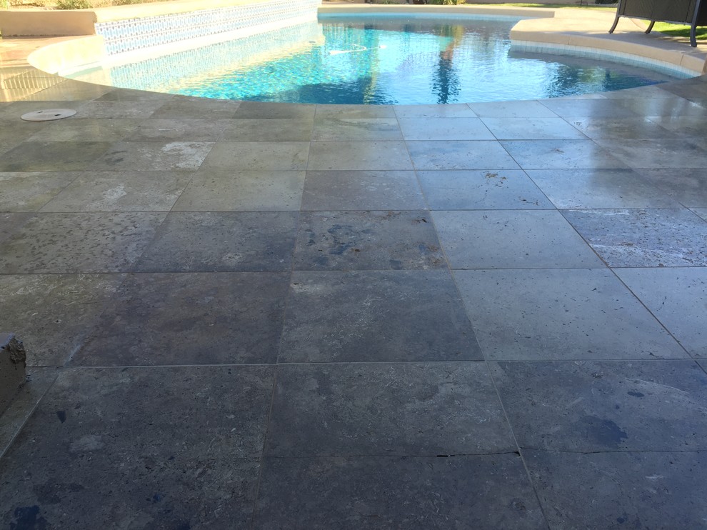 Diseño de piscina mediterránea grande en patio trasero con suelo de baldosas