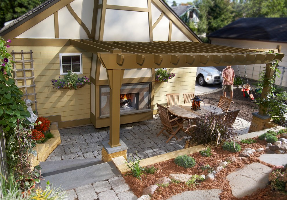 Idee per un piccolo patio o portico american style dietro casa con un focolare, pavimentazioni in mattoni e un tetto a sbalzo