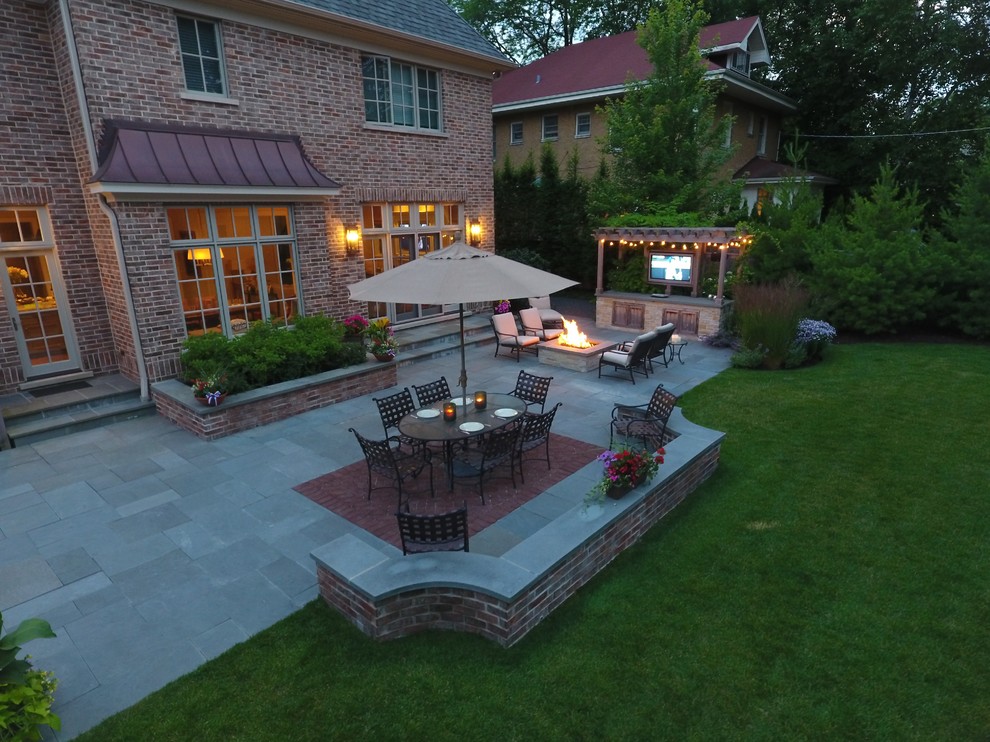 Foto di un ampio patio o portico contemporaneo dietro casa con un focolare, pavimentazioni in pietra naturale e una pergola