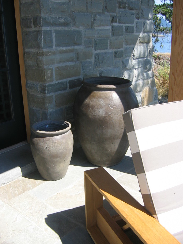 Example of a mid-sized trendy backyard stone patio design in Calgary with a roof extension and a fire pit