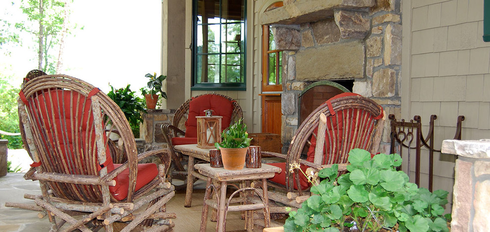 Cette photo montre une petite terrasse arrière montagne avec un foyer extérieur, des pavés en pierre naturelle et une extension de toiture.