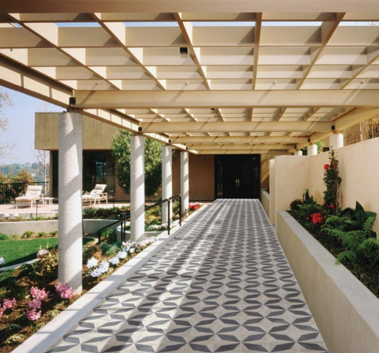 Foto di un ampio patio o portico design dietro casa con piastrelle e una pergola