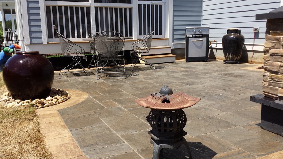 Inspiration for a world-inspired back patio in Raleigh with a water feature, concrete slabs and no cover.