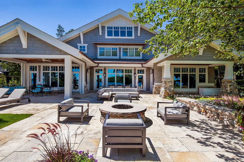 Example of a large arts and crafts backyard patio design in Grand Rapids with a fire pit