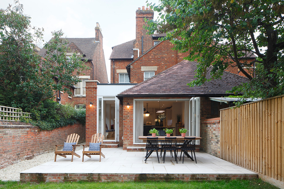 Immagine di un grande patio o portico tradizionale dietro casa con piastrelle e nessuna copertura