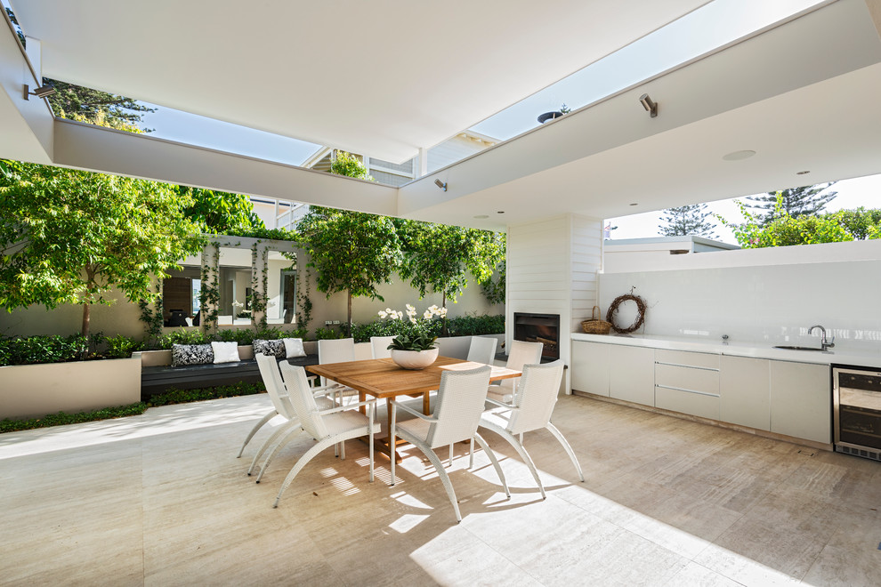 Exemple d'une terrasse arrière tendance de taille moyenne avec une cuisine d'été et une extension de toiture.