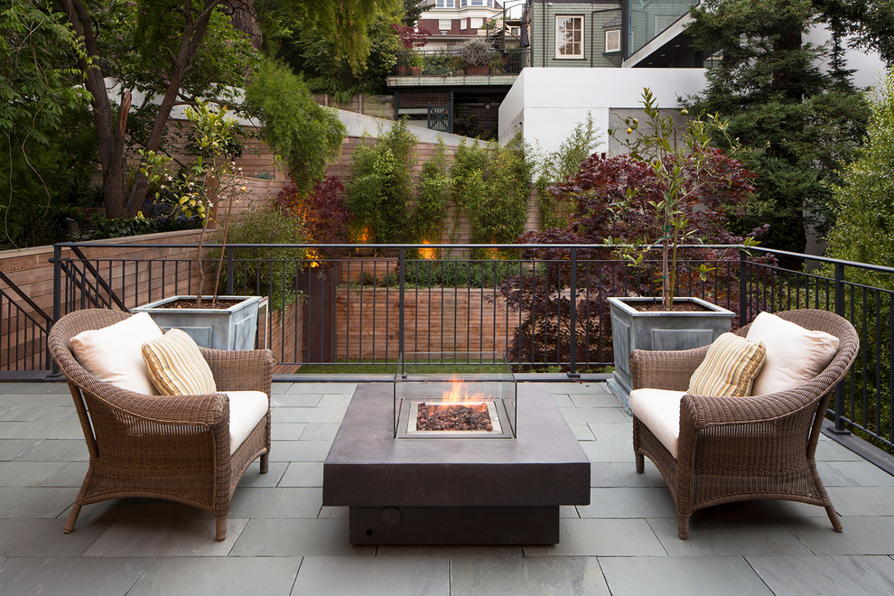 Cette photo montre une terrasse arrière chic avec un foyer extérieur et aucune couverture.