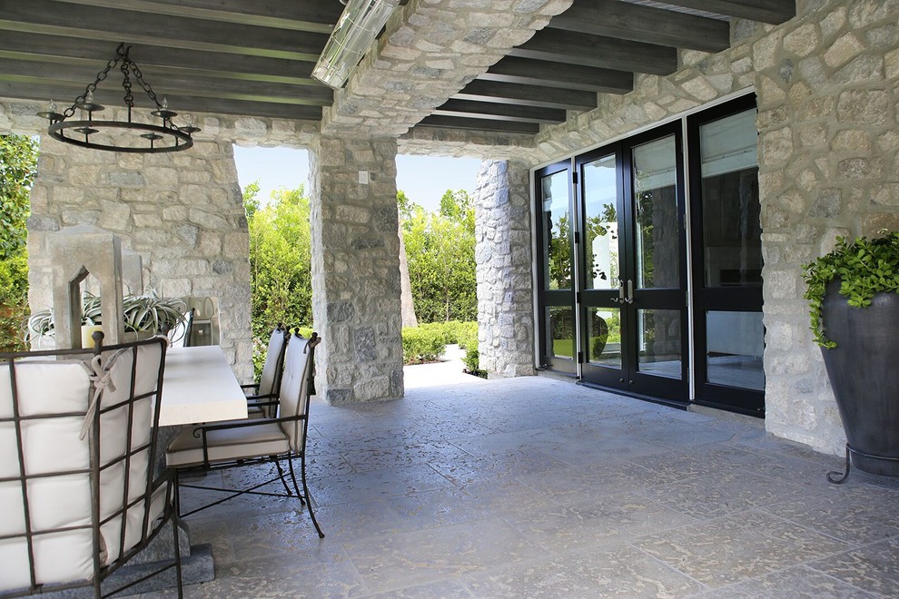 This is an example of a large rustic back patio in Los Angeles with a fire feature, concrete paving and a pergola.