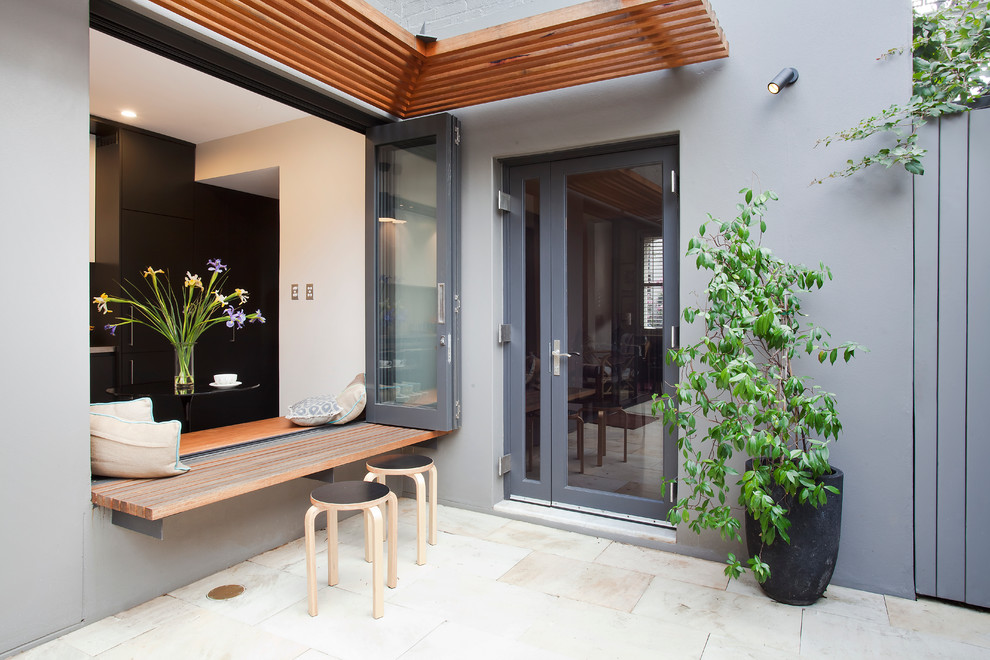 Пример оригинального дизайна: двор среднего размера на внутреннем дворе в современном стиле с покрытием из каменной брусчатки и козырьком