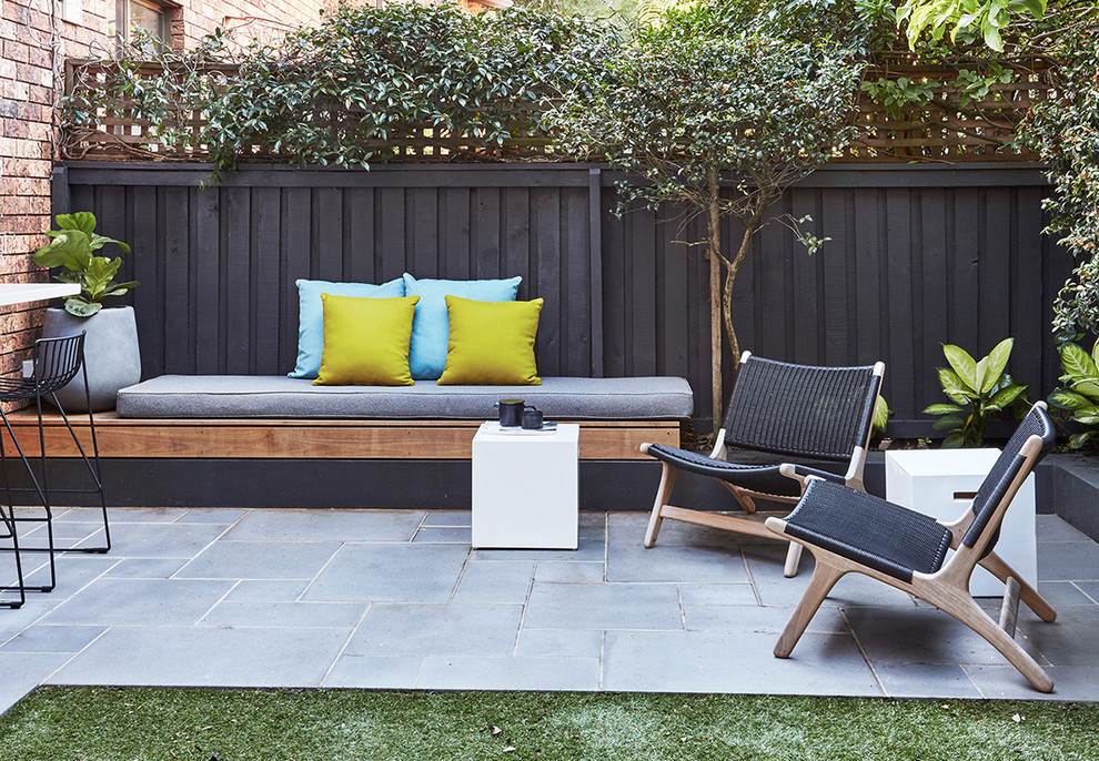 Ejemplo de patio minimalista de tamaño medio sin cubierta en patio trasero con jardín de macetas y suelo de baldosas
